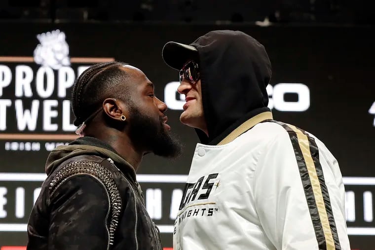 Tyson Fury, of England, right, and Deontay Wilder face off for photographers during a news conference.