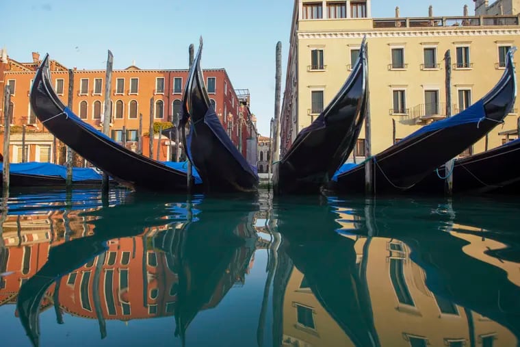 Moored gondolas are reflected on the water of the Gran Canal, in Venice on April 6, 2020. The water in Venice's canal is much clearer because there is a lack of tourist-filled gondolas and sight-seeing boats that would normally stir up sediment and make the water look cloudy.