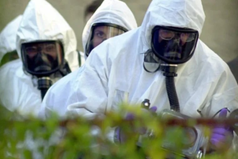 FBI officials in protective suits prepare to enter the Chester home of anthrax suspects Irshad Shaikh and his brother, Masood, in 2001.