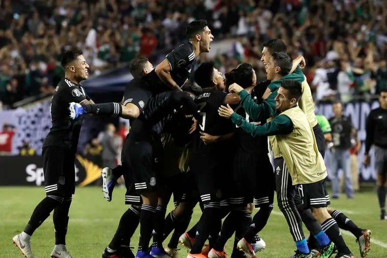 Mexico's Jonathan Dos Santos celebrates with teammates after scoring his first goal against the U.S. during the second half on Sunday.