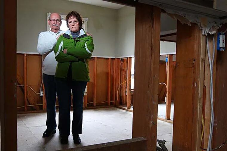 Carol and Ed Krzanowski stand in what remains of one of their bedrooms in their Manahawkin, NJ, home waiting to see what they are going to do, raise the house, or start over.  They will be featured in a sunday story about difficulties getting insurance reimbursement. they also plan to attend christie's town meeting and want to arrive early to get a good seat.  JCHRISTIE17-k  01/16/2013 ( MICHAEL BRYANT / Staff Photographer  )