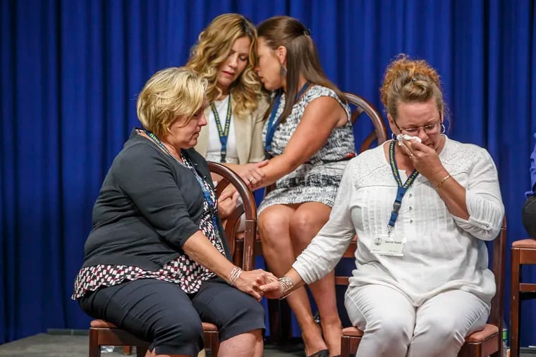 Victims of sexual abuse by priests in six Catholic Dioceses, that were seated on stage during Josh Shapiro's press conference on the Grand Jury Report, comfort each other as details of some of the abuses by specific priests are shared with the media gathered at the State Capital on August 14, 2018.