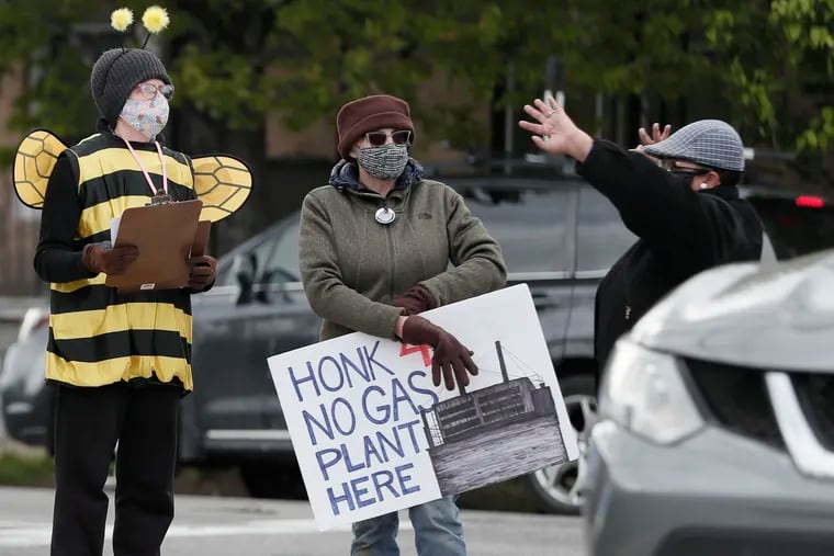 Lisa Bonitatibus (left), dressed as a bee for Toxic Free Philly, with State Rep. Darisha Parker (far right) during a protest outside the SEPTA Midvale Depot in Philadelphia on April 22.