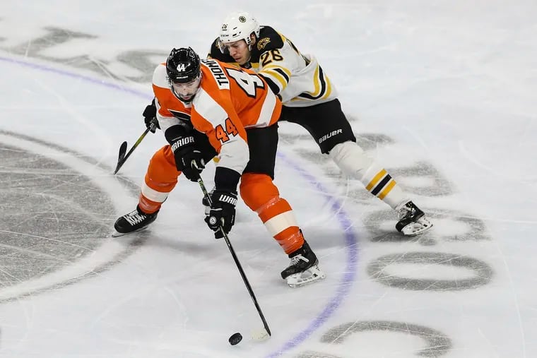 Flyers center Nate Thompson keeps the puck from Boston's Par Lindholm during a March 10 game at the Wells Fargo Center. Thompson injured his left knee in the game.