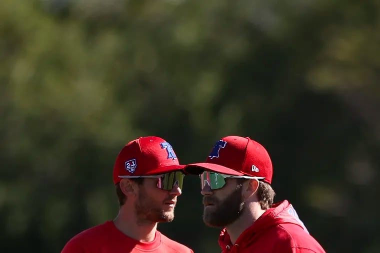 Trea Turner, left, and Bryce Harper warm up for their first official day of spring training.