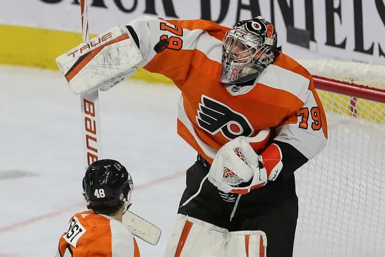 Flyers goalie Carter Hart stops the puck over Morgan Frost against the Jets during the first period at the Wells Fargo Center in Philadelphia, Tuesday, February 1, 2022.